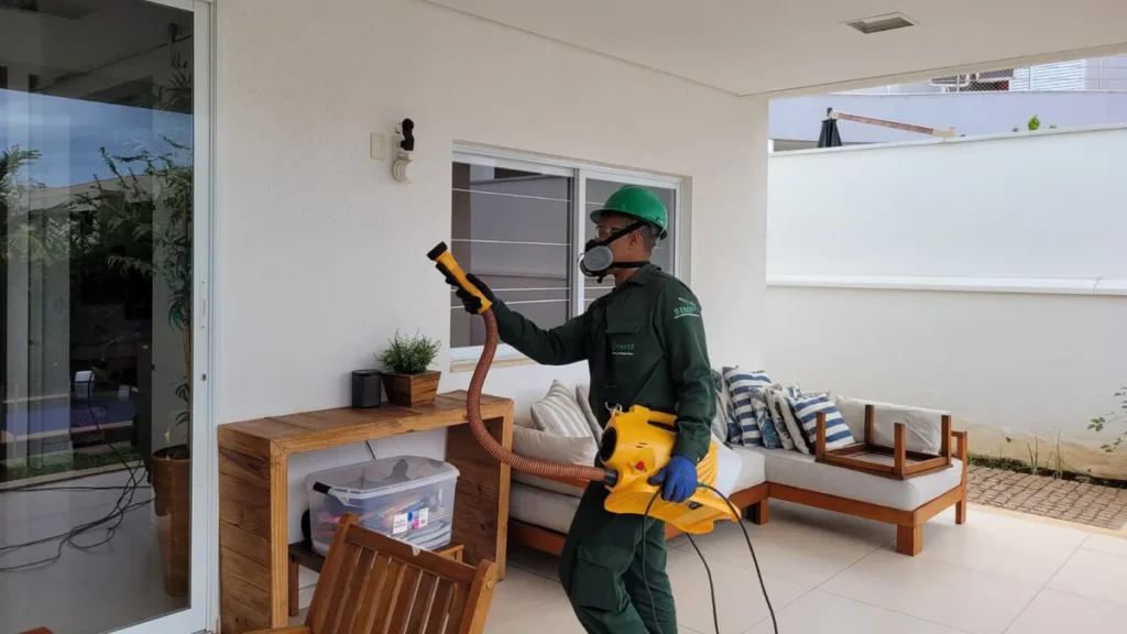 Técnico da Detecta fazendo dedetização preventiva em área externa de casa