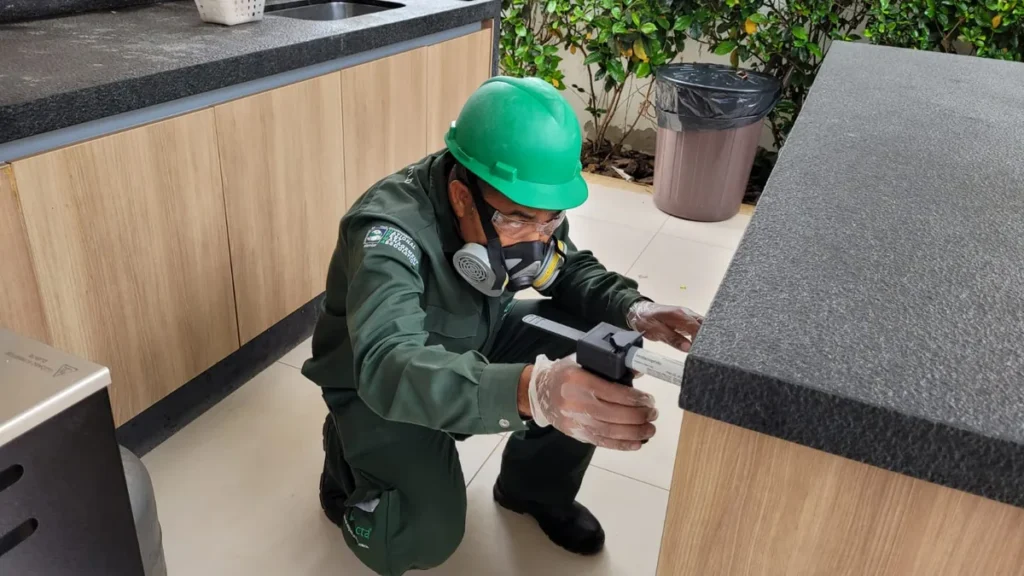 Técnico aplicando gel em bancada de cozinha, método que dispensa sair de casa
