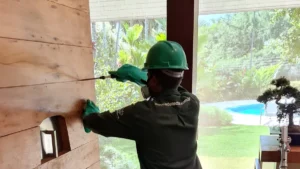 Técnico da Detecta fazendo descupinização por injeção em painel de madeira