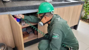 Técnico uniformizado e com EPI da Detecta inspecionando armário